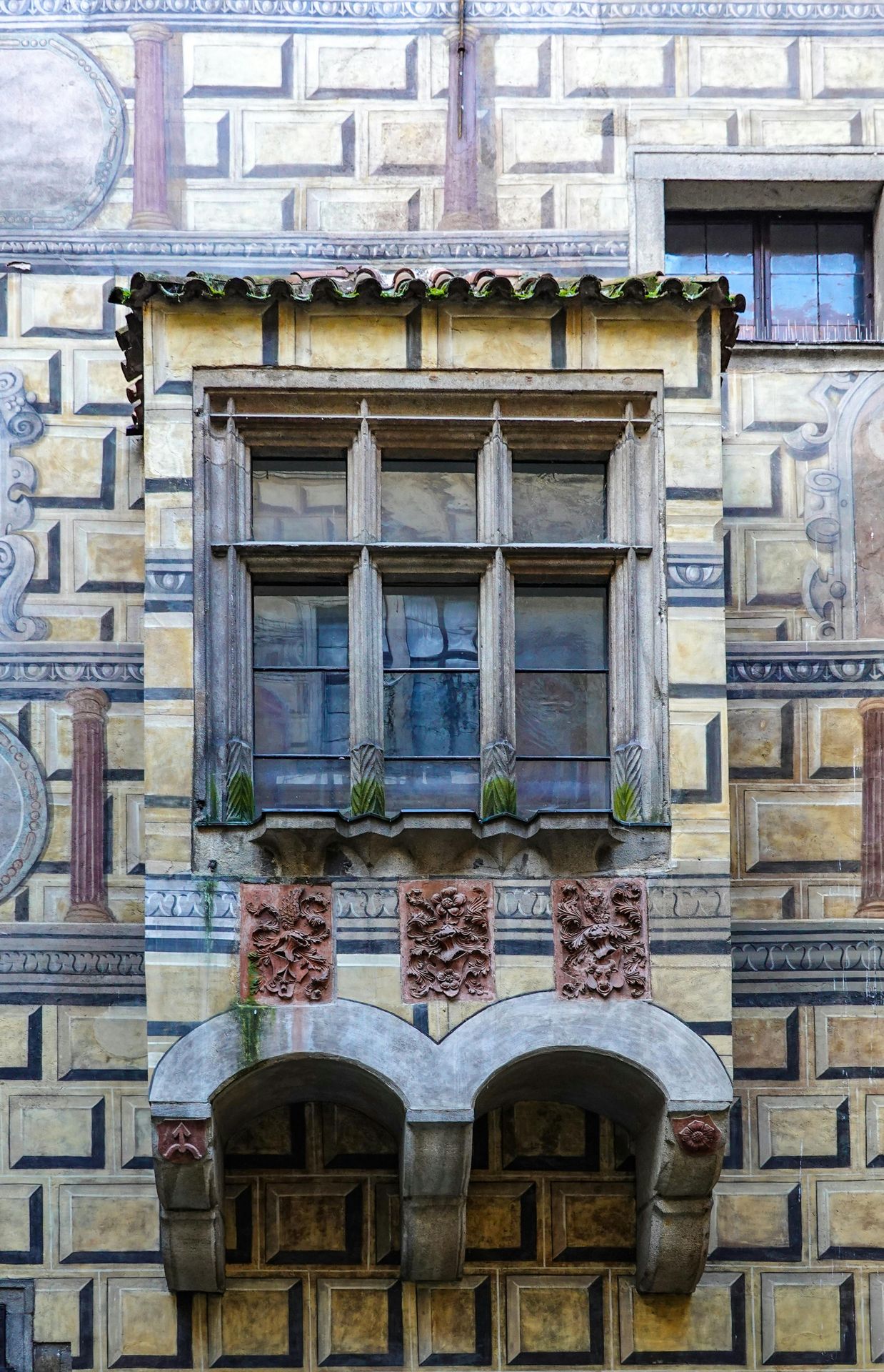 A close-up of the Český Krumlov Castle with ivy-covered walls and intricate architectural details.