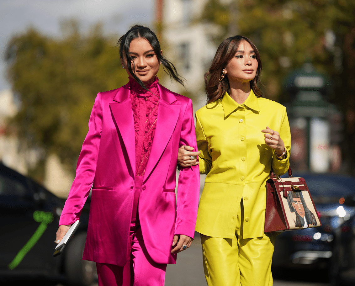 Two models in dopamine dressing-inspired outfit, featuring bold, vibrant hues of magenta, yellow, and gold.