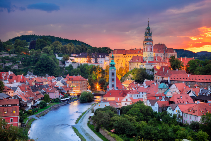 A wide-angle shot of the cobbled streets of Český Krumlov at dawn, with golden light casting long shadows.