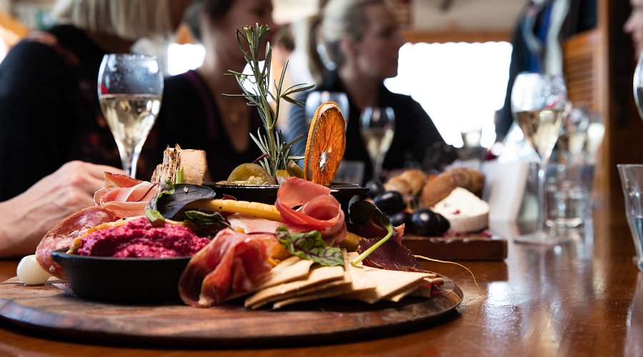 A rustic, candlelit restaurant by the river, with a glass of Moravian wine and a plate of roasted duck.